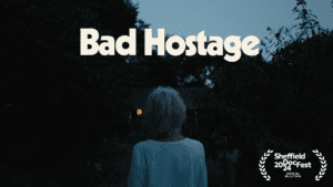 A promo image for the film "Bad Hostage" feature the back of and old woman as she looks towards a house.