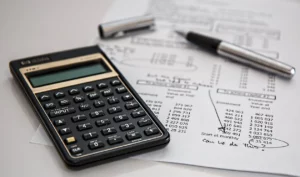 A calculator along side a budgeting sheet.